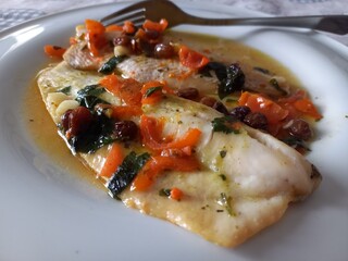 Filetto di merluzzo al cartoccio, con pomodorini di pachino, olive, aglio, prezzemolo, olio e uvetta passa