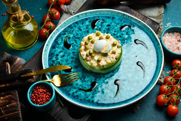 Olivier salad. Salad of green peas, boiled vegetables and mayonnaise. Close-up, gray background.