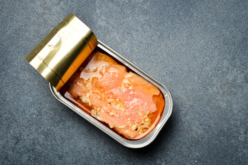 Canned of pickled salmon fillet set in a metal jar. Canned food in aluminum cans. On a gray...