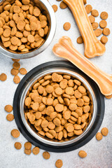 Dogs' food in metal a plate. Dry animal feed in a bowl close up. Dry food for puppies or dogs in a small bowl. Close up.
