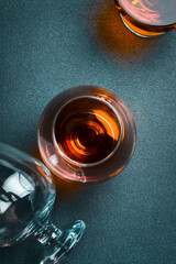 A glass with aged cognac or brandy on a dark table. Strong aged alcoholic drinks. On a concrete...