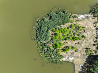 Lake District  swallow hole flooded as a result of the mining damage Pomorzany mine in Olkusz,Poland. Aerial drone view of flooded sand pit. Forest submerged in a lake. Sunken sandpit with clear water