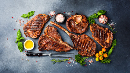 Delicious grilled steak. Set of beef steaks: Tomahawk, T-bone, Ribeye and Ossobuco. Top view. On a...