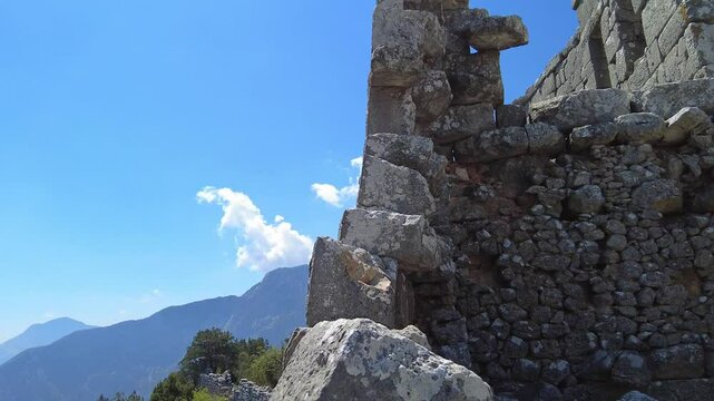 4K Circular pan from hills to stone walls behind stage of ancient Termessos theater, Pisidian city hidden in the Taurus Mountains (Gulluk Mountain) near Antalya, Turkey