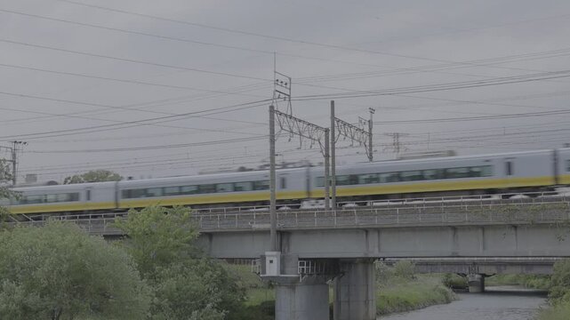 千葉県柏市の大堀川を上野・東京方面へ渡る常磐線E657系K2編成のイエロージョンキル塗装された特急電車