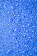 Drops of spring water on a blue textured background.