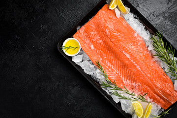 Fresh salmon or trout sea fish fillet. In a metal tray with lemon and rosemary. On a stone...