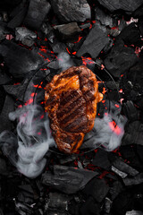 Juicy prime ribeye steak on the grill, close-up. Black Angus steak. On charcoal. Top view.