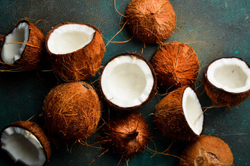 Set or collection of fresh ripe whole and half coconut. Top view. On stone background.
