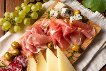 Tagliere con prosciutto crudo, gorgonzola, salame e pecorino, olive e uva bianca, antipasti...
