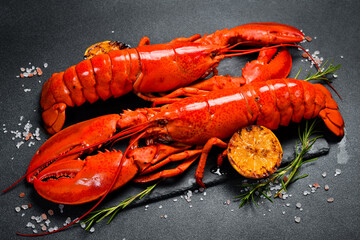 Steamed red lobsters with lemon, ready to eat. Side view. Close-up.