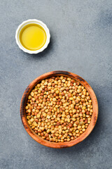 Soybean oil. A bowl of soybeans and oil in a saucepan. On a stone background