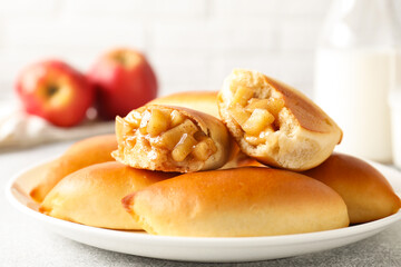 Tasty baked patties with apples on light grey table, closeup