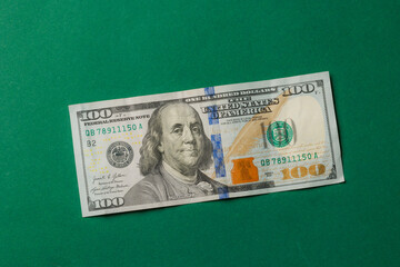 Detail of a one hundred dollar bill featuring Benjamin Franklin on a green background for financial education or currency study