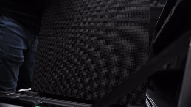 Worker placing LED panel into transport case