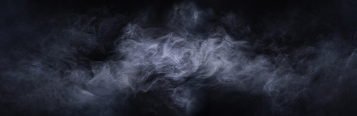 Abstract smoke texture over black background. Fog in the darkness.
