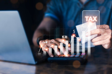 Entrepreneur is calculating income and using laptop to fill online income tax form for payment....