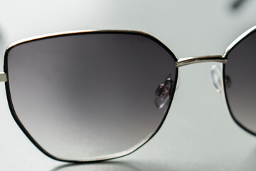 Close-up of stylish sunglasses with dark lenses and metal frame on a white background