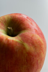 A close-up image of a fresh red and green apple with a smooth surface on a white background.