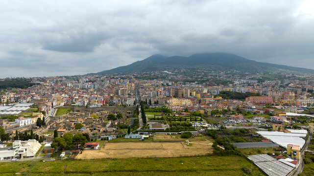 Aerial view of the archaeological area of ​​the excavations of Herculaneum. It was an ancient Roman city. In the background the modern city of Ercolano and Vesuvius volcano, province of Naples, Italy.