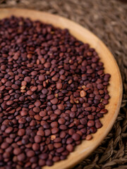 Organic uncooked seeds dark red brown lentils.