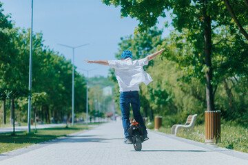 Man Riding Electric Unicycle in the Park With Arms Wide Open © Alexandr