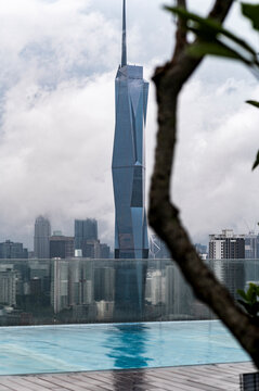 View of Merdeka tower through rooftop foliage, Kuala Lumpur, Malaysia