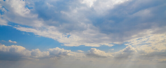 Obraz premium White cumulus clouds in a blue haze in the sky, high clouds soaring in the sky to the horizon, cloud texture in the blue sky as a background.