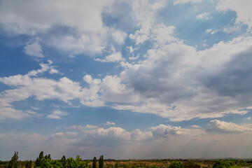 Cumulus clouds in the sky over fields to the horizon, sky with clouds over a rural landscape,...
