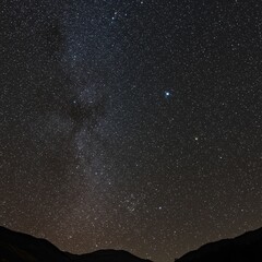 Obraz premium Starry Night Sky Over Dark Mountains in the Peaceful Outdoors
