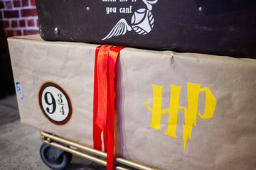 Naklejka premium Colorful luggage Harry Potter themed for fictional magical adventure on a trolley cart