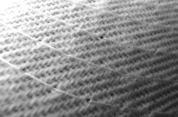 Patterned Fabric with Visible Threads and Gradient Lighting: Woven material with diagonal lines, transitioning from a bright upper corner to a darker lower section