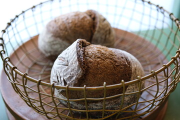 Fresh loaves of bread and buns in rustic bakery, baked goods on rustic background and countryside...