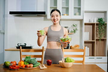 Woman Preparing Healthy Meal in Kitchen, Fit Woman Making Smoothie and salad with Fresh Ingredients at home. Active healthy lifestyle, clean eating concept