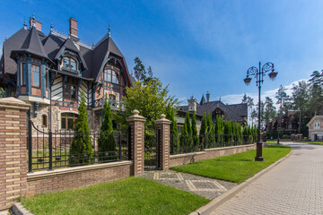 A cottage in Gothic style, illuminated by the sun on a clear summer day. Characteristic...