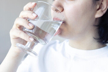 Young woman holding glass of water. Drinking water from a glass	