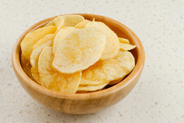 Potato Chips, served in wooden bowl on white background.
