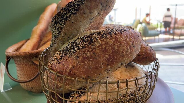 Wicker basket with different types of fresh bread on wooden table. High quality