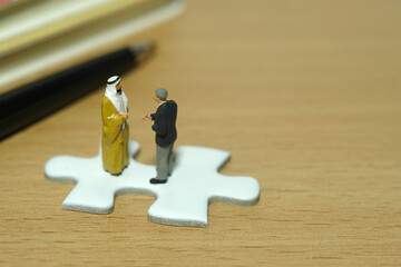 Miniature people toy figure photography. Partnership concept. A Sultan and businessman make an...