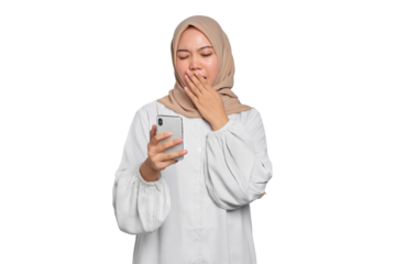 Confused young Asian Muslim woman holding mobile phone and feeling sleepy isolated on transparent background