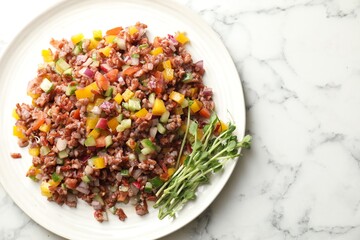 Tasty salad with brown rice on white marble table, top view. Space for text