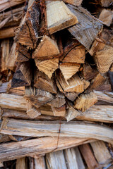 A stack of split firewood with rough textures and natural wood grain, ready for burning