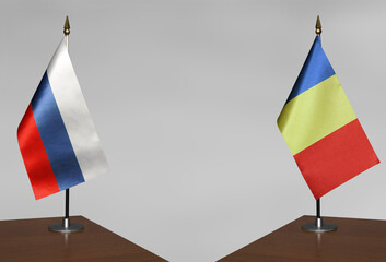 Table flags of Romania and Russia on a gray blurred background