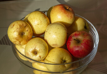 Glass Bowl of Fresh Yellow and Red Apples in Natural Sunlight