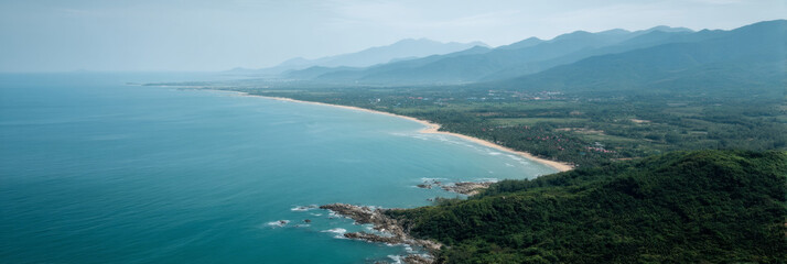 Naklejka premium Majestic emerald coastline embraces azure waters, echoing tranquility and exploration; ideal for World Oceans Day or Ecotourism Celebration