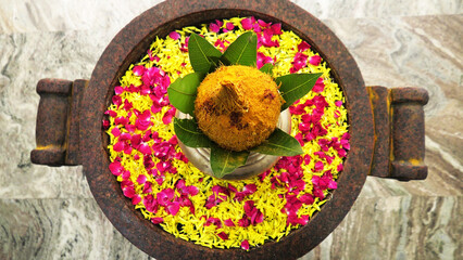 Special divine preparation with golden pot, coconut, and flower petals used in auspicious...