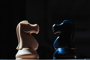 Two knights facing each other on chessboard symbolizing strategic rivalry