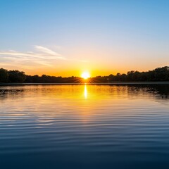 Fototapeta premium Sunset reflecting on tranquil water with trees in the background. Golden hour lens flare concept.