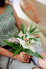 Woman in Pastel Outfit Relaxing and Holding Beautiful Lilies Indoors