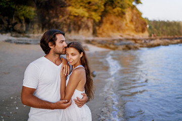 Love and romance. Honeymoon on the sea shore. Happy loving couple embracing on the beach.